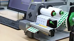 Tischdrucker bei Labelident im Einsatz zur Herstellung bedruckter Etiketten &ndash; Beginn der eigenen Etikettenproduktion im Jahr 2007.