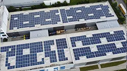 Luftaufnahme des Labelident-Geb&auml;udes mit gro&szlig;fl&auml;chiger Photovoltaikanlage auf dem Dach &ndash; nachhaltige Energiegewinnung f&uuml;r die Etikettenproduktion.