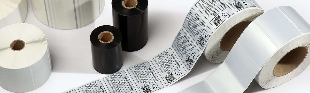 Typenschilder auf Etikettenrolle zusammen mit Farbbändern für langlebige Produktkennzeichnungen.