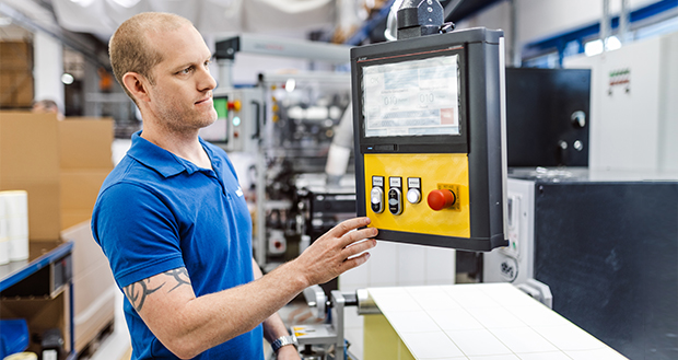 Labelident Mitarbeiter bedient eine Produktionsmaschine.